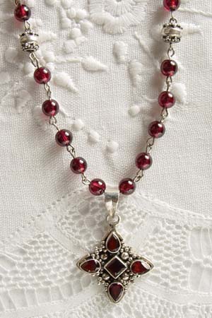 Garnet w 1-1/4 in faceted garnet cross